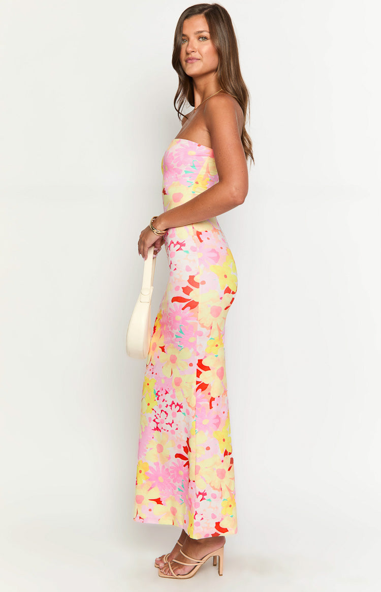 Side view of a strapless maxi dress with a vibrant pink, yellow, and red floral print