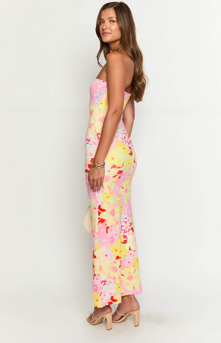 Side view of a strapless bodycon maxi dress in a yellow, pink, and red floral print