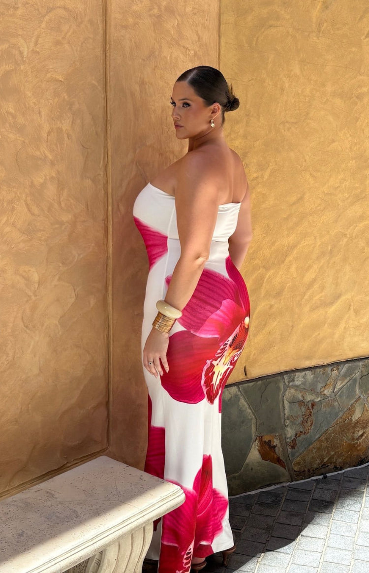 Side view of a white strapless maxi dress with a large pink orchid print and fitted silhouette
