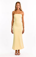 A model wears a bright yellow crepe maxi dress. This formal dress features a strapless straight neckline and a luxurious crepe fasbric. An elegant choice for a wedding guest or graduation dress.