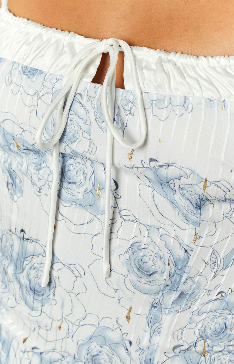 Close-up of the white drawstring detail and ruched band on a blue floral mini dress with gold foil accents
