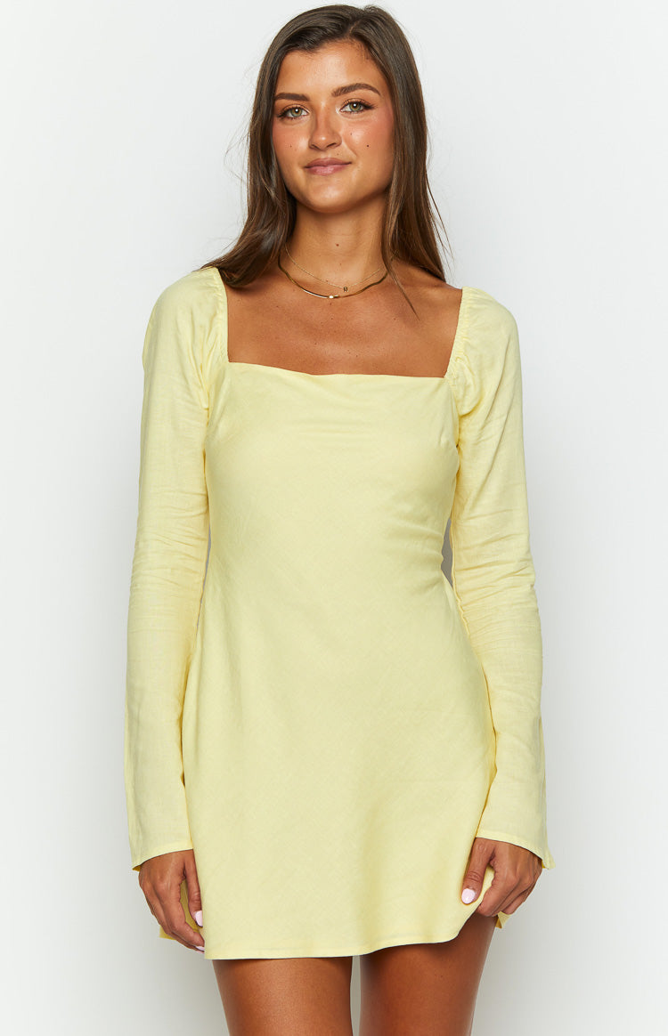 Yellow mini dress with a square neckline, long sleeves, and a light textured fabric