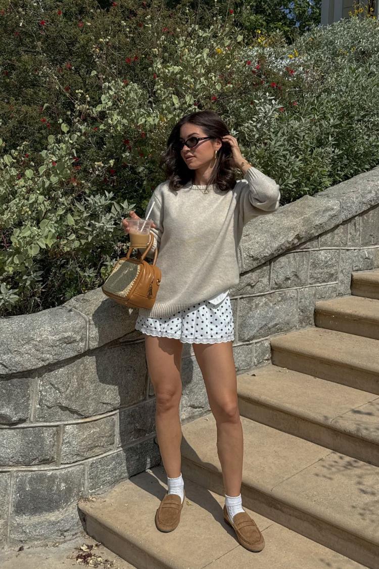 White polka dot shorts featuring a delicate white lace trim at the hem and a relaxed fit