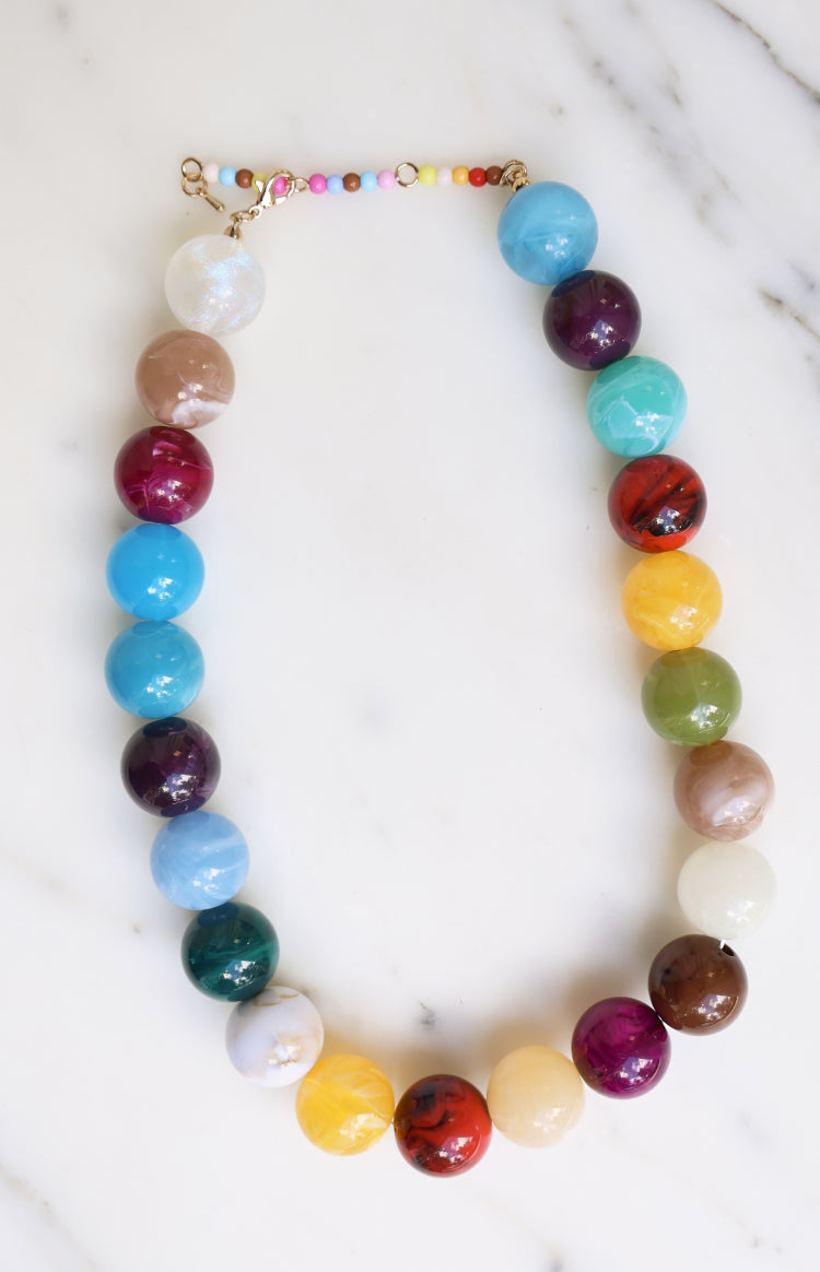 Multi-coloured necklace with large round marbled and solid beads in various shades, featuring a seed bead extender chain and