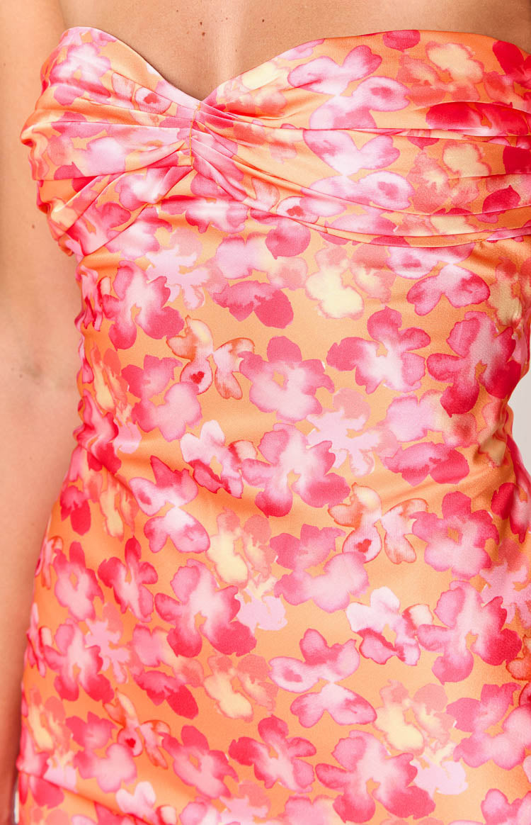 Close-up of the pink and orange watercolor floral print and twisted strapless bust of the maxi dress