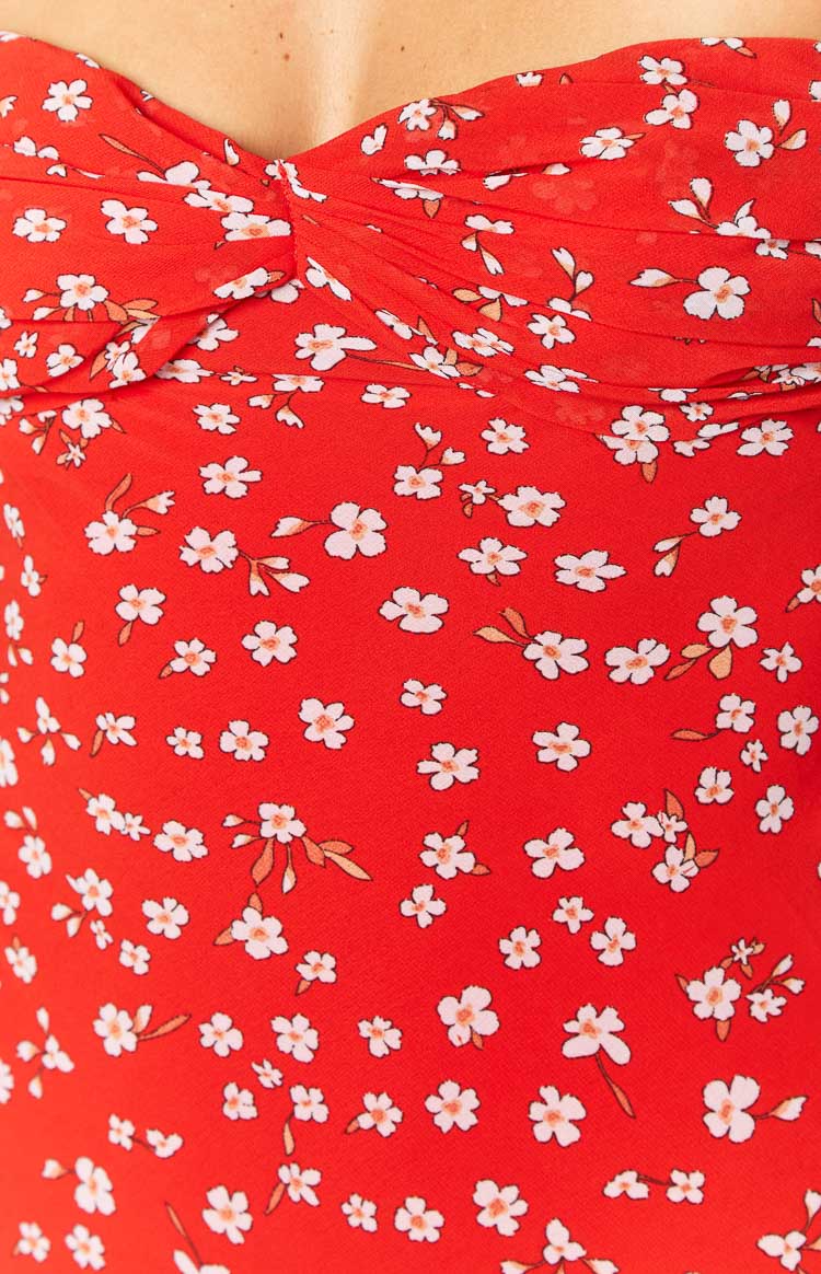 Close-up of the red fabric with white floral print and ruched bust detail on the maxi dress
