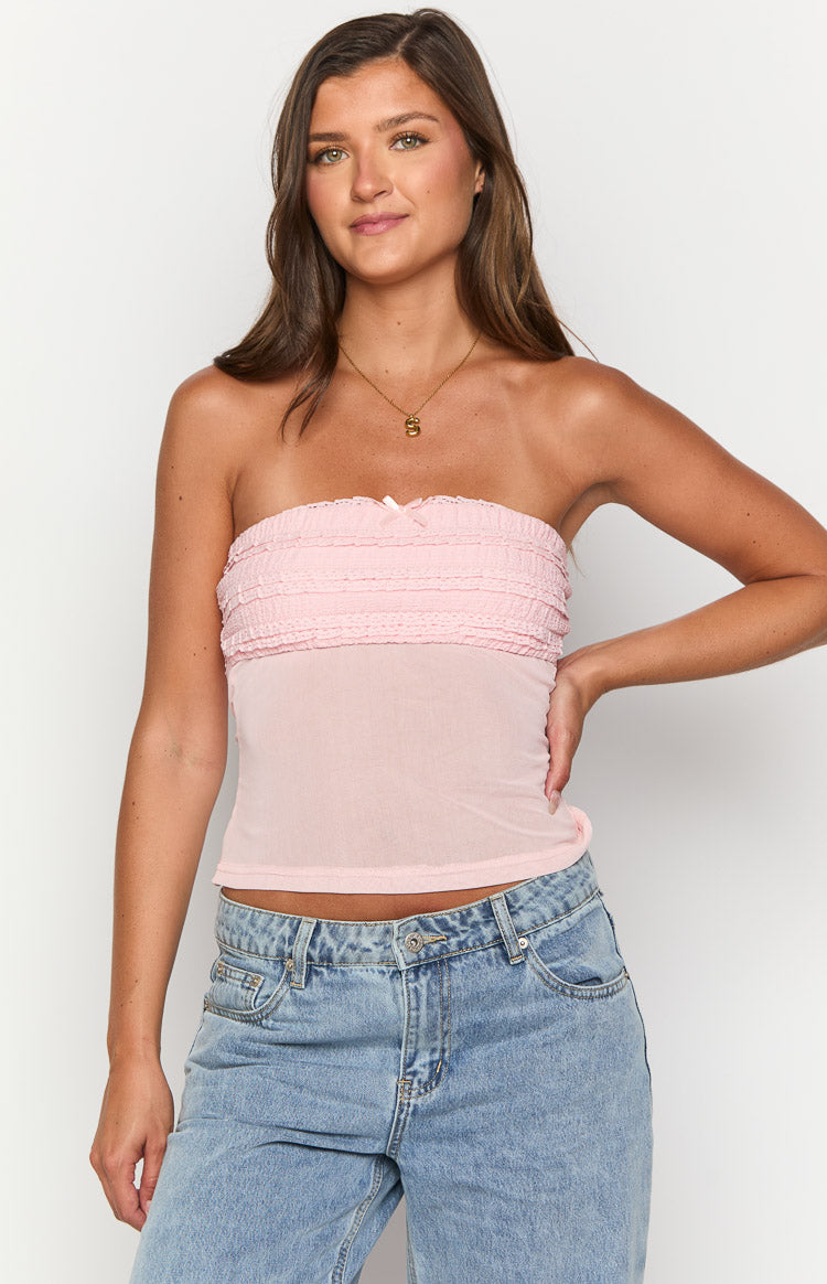 Light pink strapless top with a shirred bust, small front bow, and sheer mesh fabric