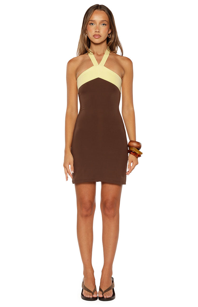 Front view of a brown jersey mini dress with a light yellow halter neckline and fitted silhouette