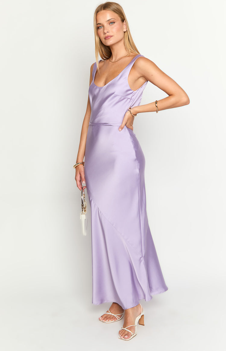 Side view of a purple satin maxi dress with a scoop neckline, wide straps, and a panelled bias-cut skirt