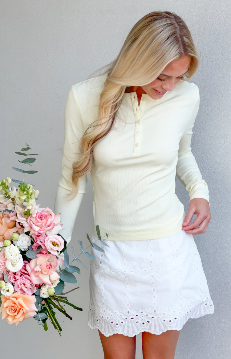 White broderie mini skort with a scalloped hem and intricate eyelet embroidery