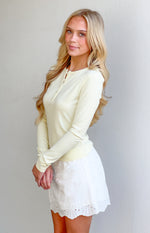 White broderie anglaise mini skort with eyelet cutouts and a scalloped hem