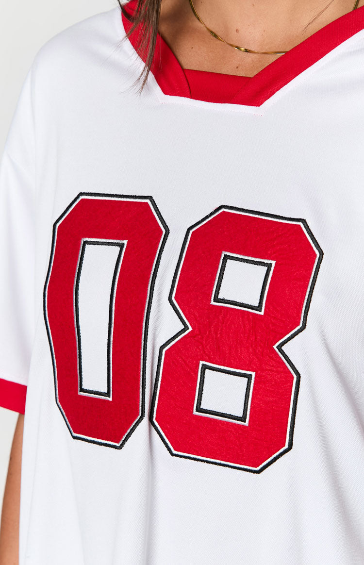 Detail shot of the red V-neck trim and embroidered red number 08 with black outline on a white jersey mini dress