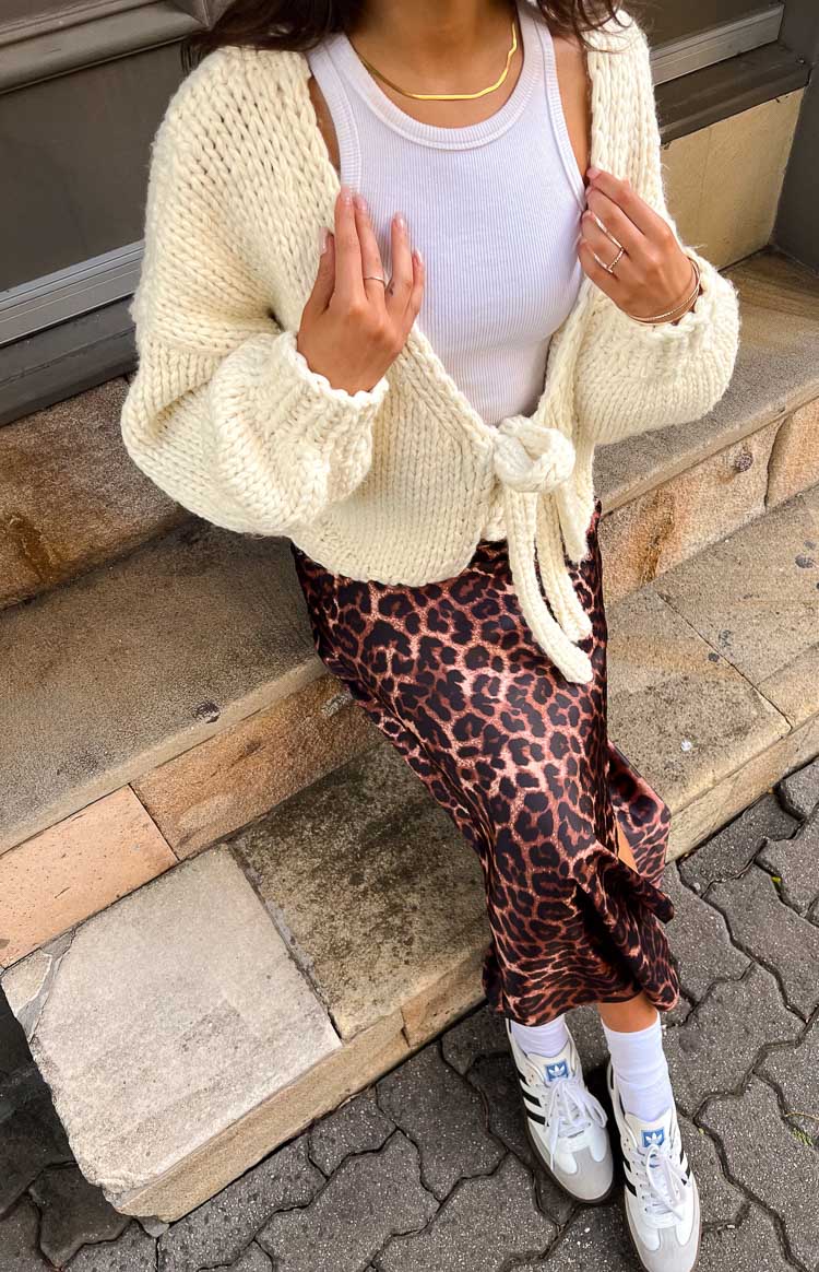 Close-up of a cream chunky knit tie-up cardigan with wide sleeves and an open front