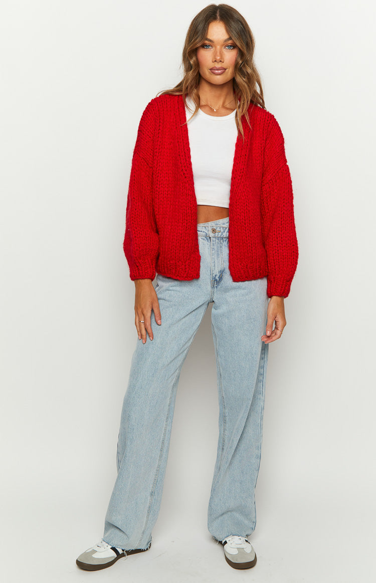 Front view of a relaxed fit red chunky knit cardigan with long sleeves, worn open