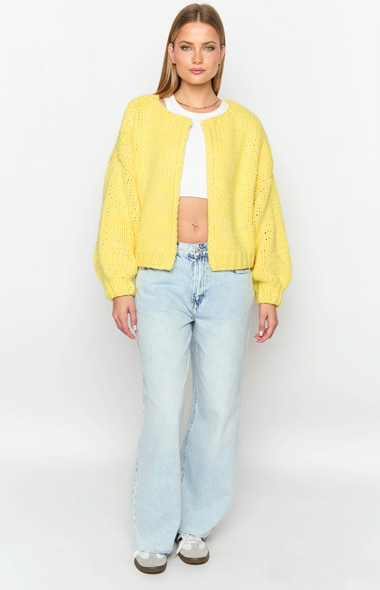 Collarless yellow chunky knit cardigan with an open front, dropped shoulders, and long balloon sleeves