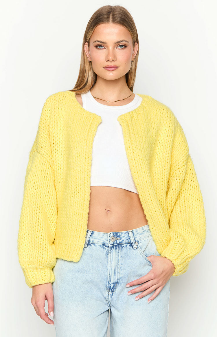 Front view of a bright yellow chunky knit cropped cardigan with an open front