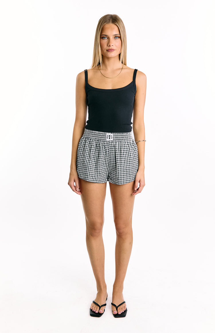 Front view of black and white gingham shorts with a high elasticated ruched waistband and small logo label
