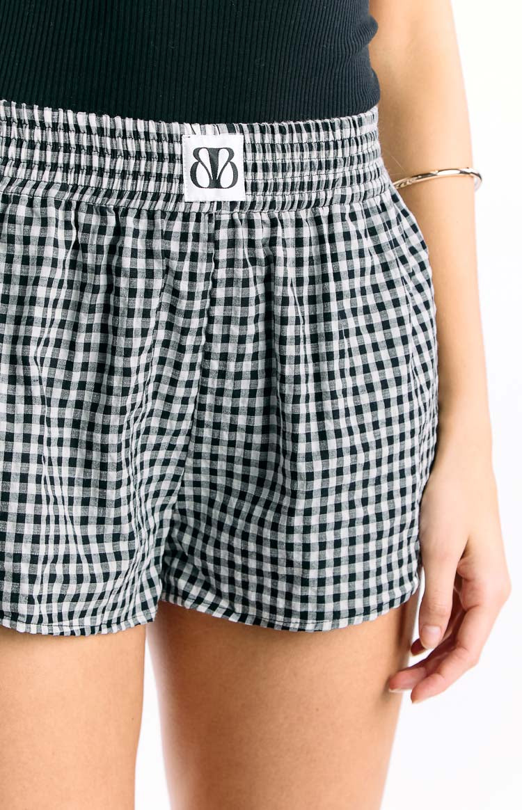 Close-up of the black and white gingham shorts showing the shirred elastic waistband and soft fabric texture