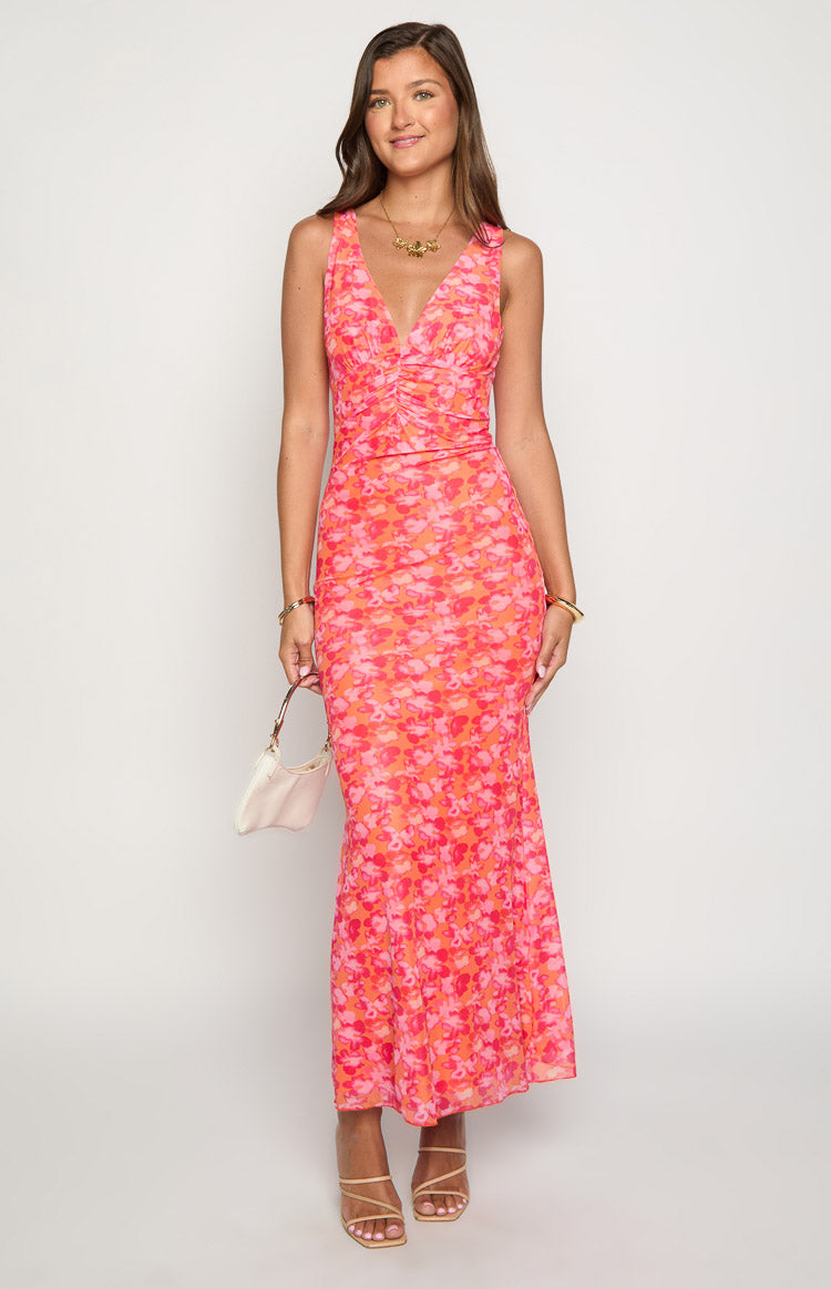Front view of an orange and pink floral print maxi dress with a V-neckline and ruched bodice
