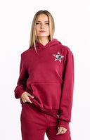 A red outerwear featuring an oversized hoodie with a white star applique on the chest. Perfectly paired with sweatpants or Dania Burgundy Leopard Star Track Pants.
