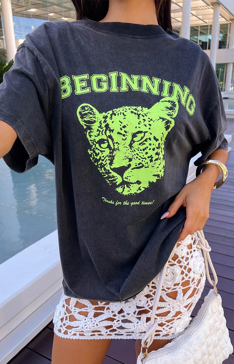 Close-up of the washed black tee featuring a neon green leopard graphic and 'BEGINNING' text