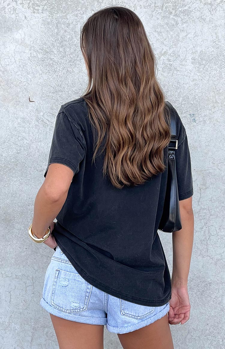 Rear view of a faded black oversized tee with short sleeves, showing its relaxed fit and soft drape