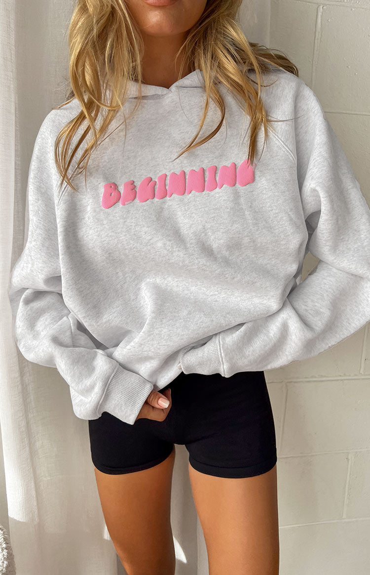 Close-up of the grey marl oversized hoodie showing the pink bubble text on the chest and ribbed cuffs