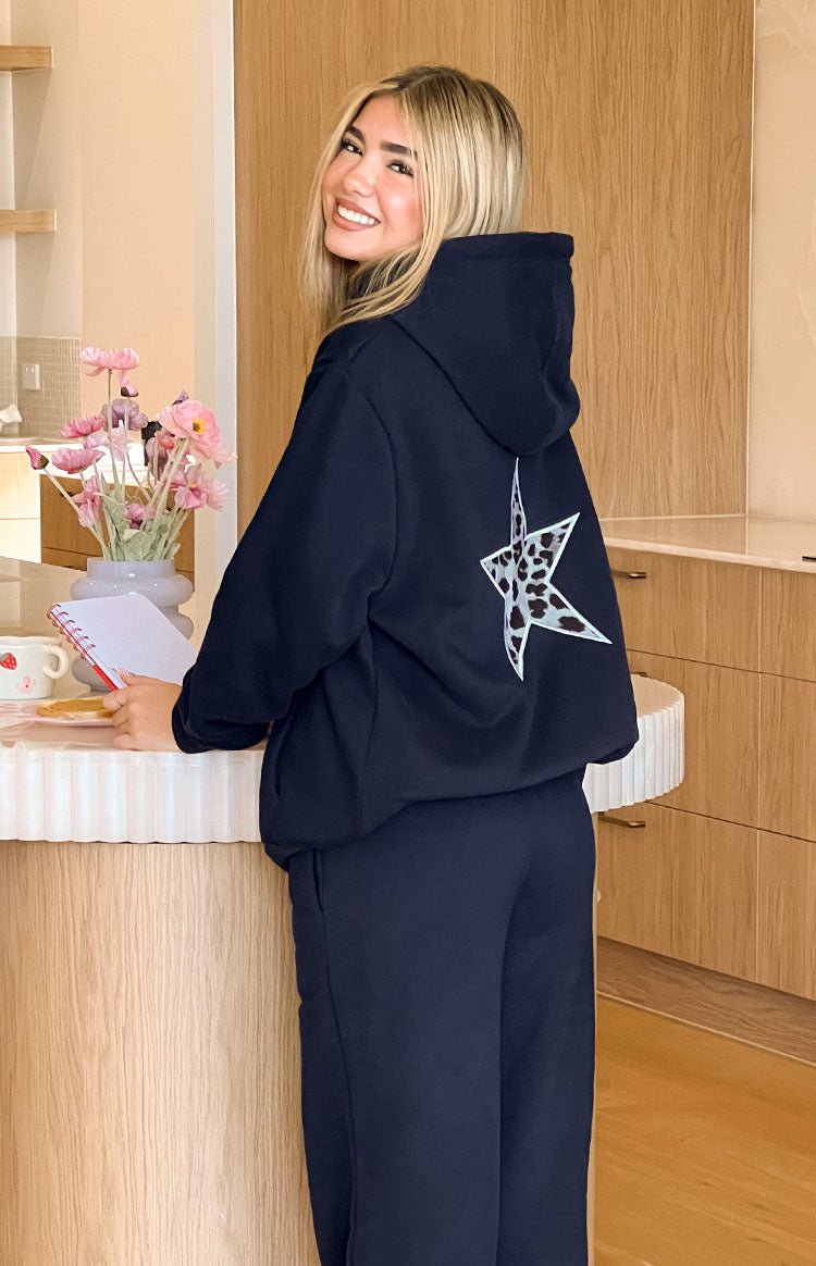 Rear view of a navy oversized hoodie with a large white and black leopard print star on the back