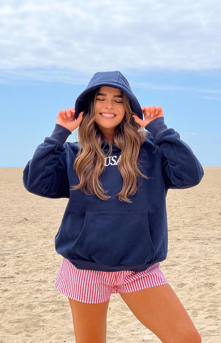 Navy oversized hoodie with the hood up, showing the white USA graphic print and a large front kangaroo pocket