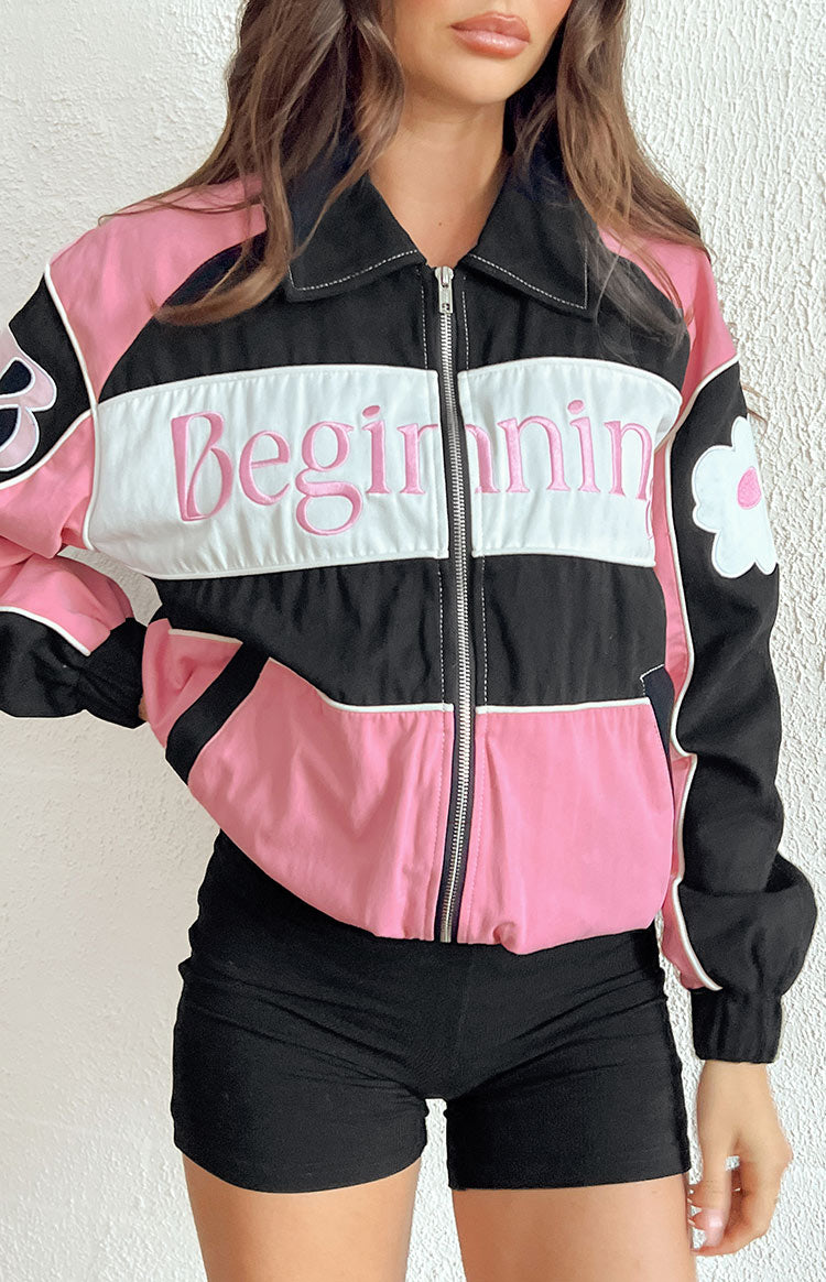 Close-up of the black collar with white stitching, silver zipper, and pink Beginning embroidery on a bomber jacket