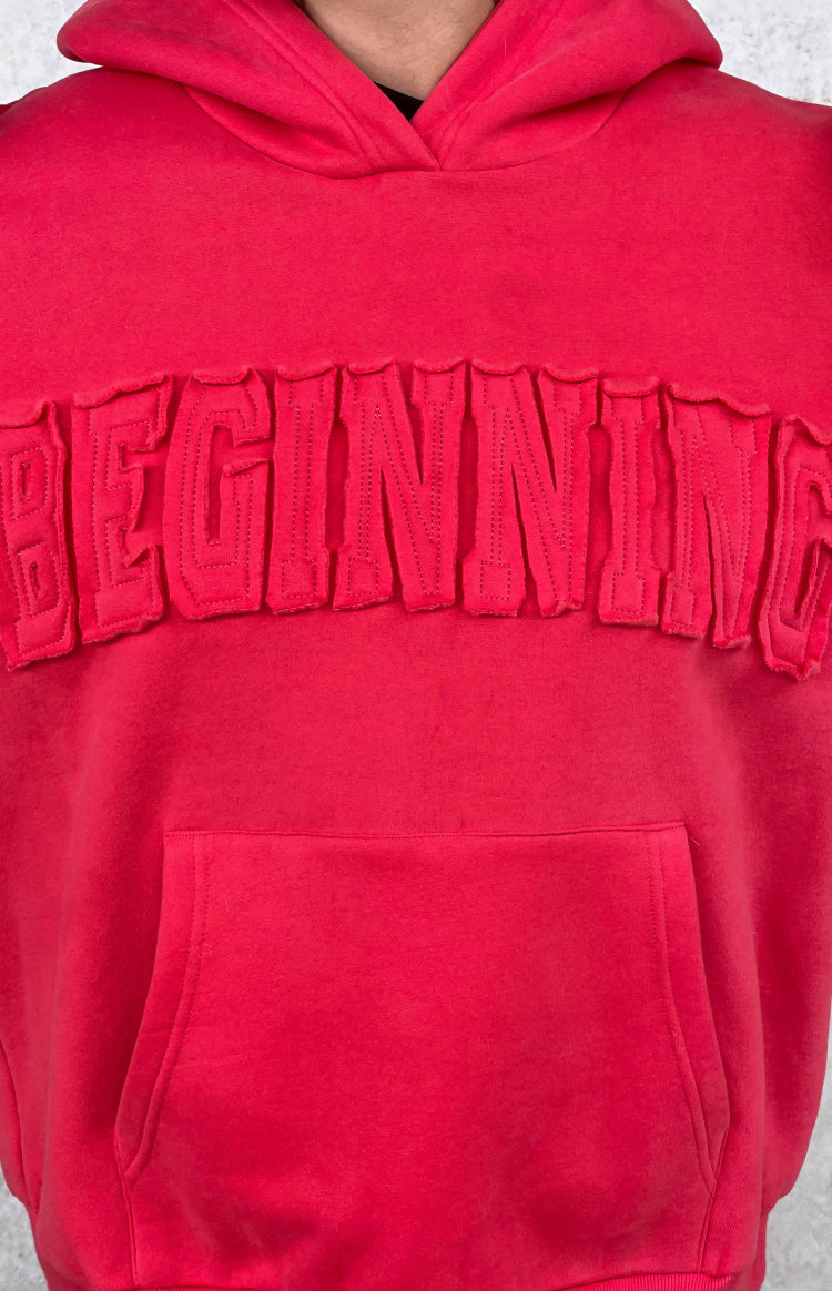 Close-up of the watermelon red hoodie's BEGINNING applique text with raw edges and front kangaroo pocket