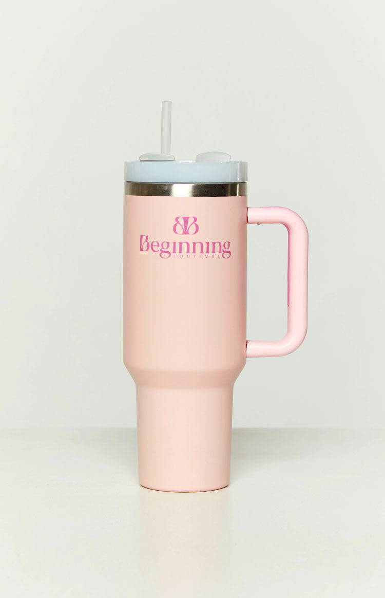Front view of a bubblegum pink tumbler with a light blue lid, clear straw, and a pink side handle