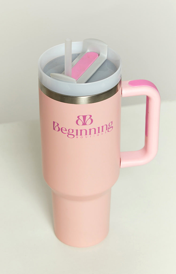 Bubblegum pink tumbler with a clear plastic lid, a visible straw, and a matching pink handle and slider