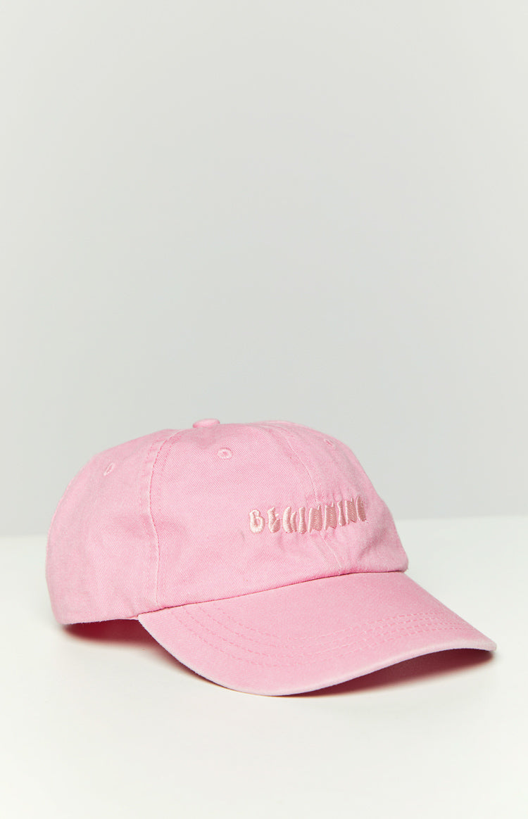 Pink washed cap with embroidered "BEGINNING" text on the front