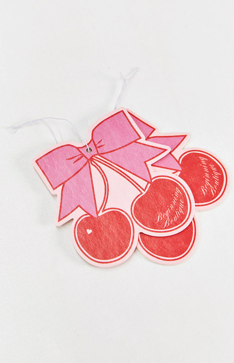 Multiple pink and red cherry-shaped air fresheners layered together, showing the felt-like texture and white hanging strings