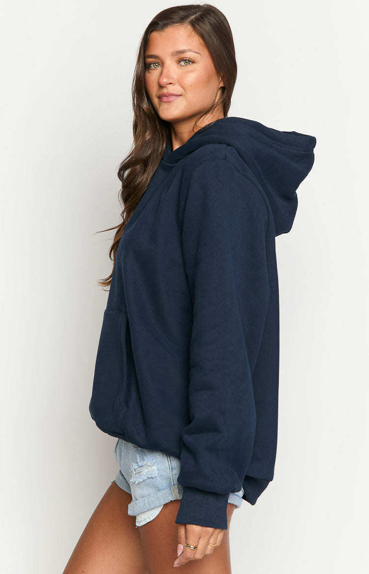Side view of a navy oversized hoodie with a relaxed fit, long sleeves, ribbed cuffs, and a front kangaroo pocket