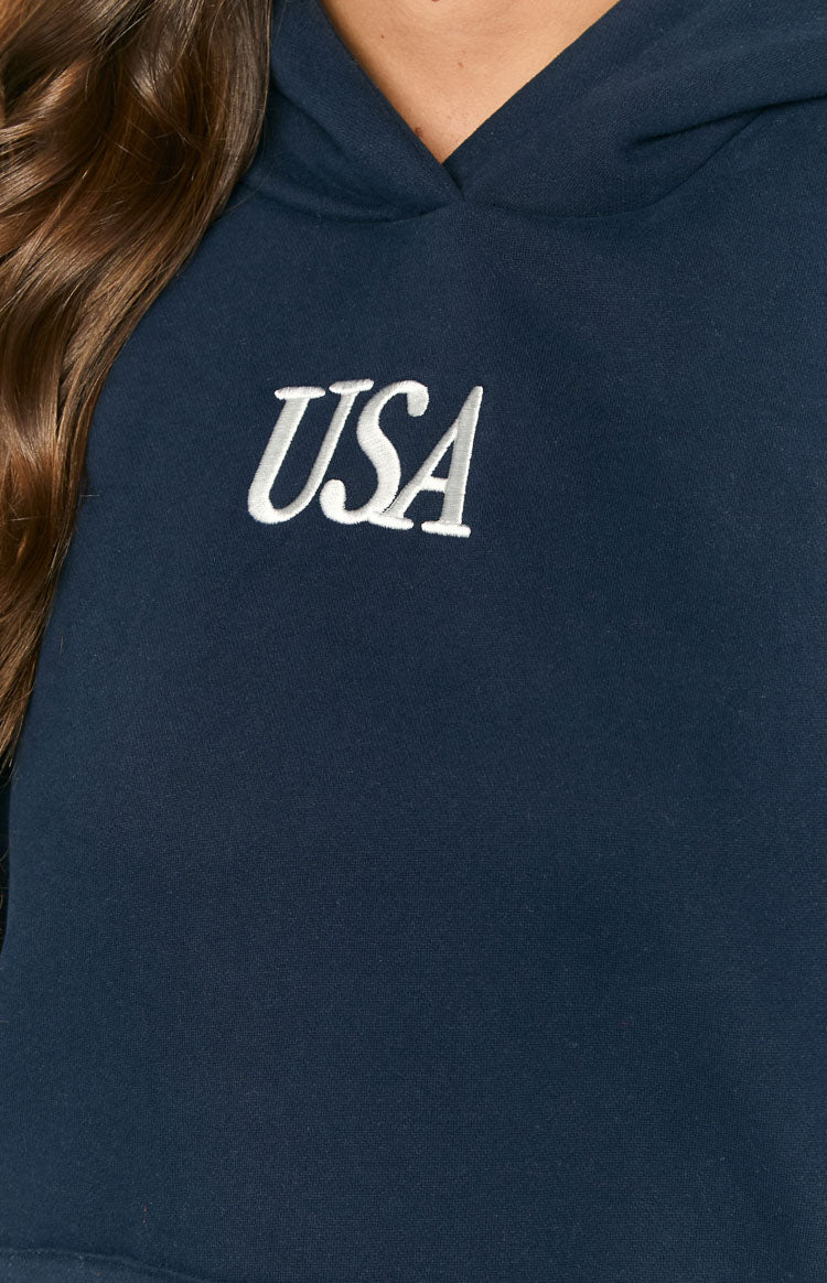 Close-up of the navy hoodie showing white embroidered "USA" text on the chest