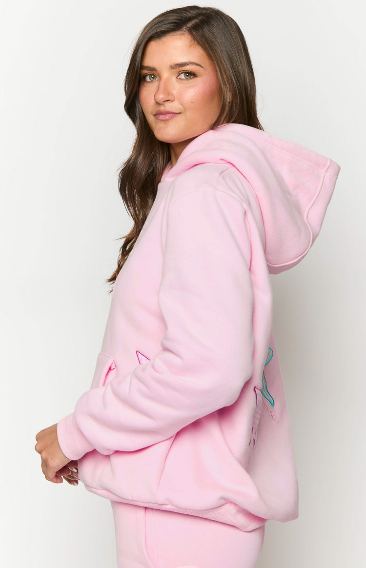 Side view of a pink oversized hoodie with a hood, long sleeves, and a blue and green graphic on the back