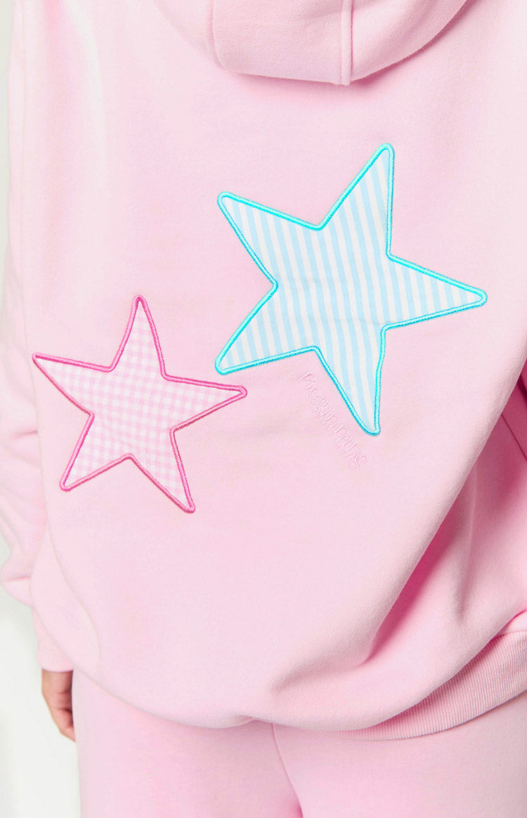 Back detail of a pink hoodie with a pink gingham star, a blue striped star applique, and subtle embroidery