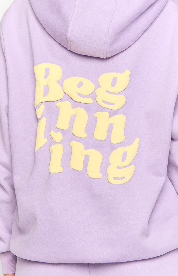Close-up of the back of a purple hoodie with large, raised yellow 'Beginning' text