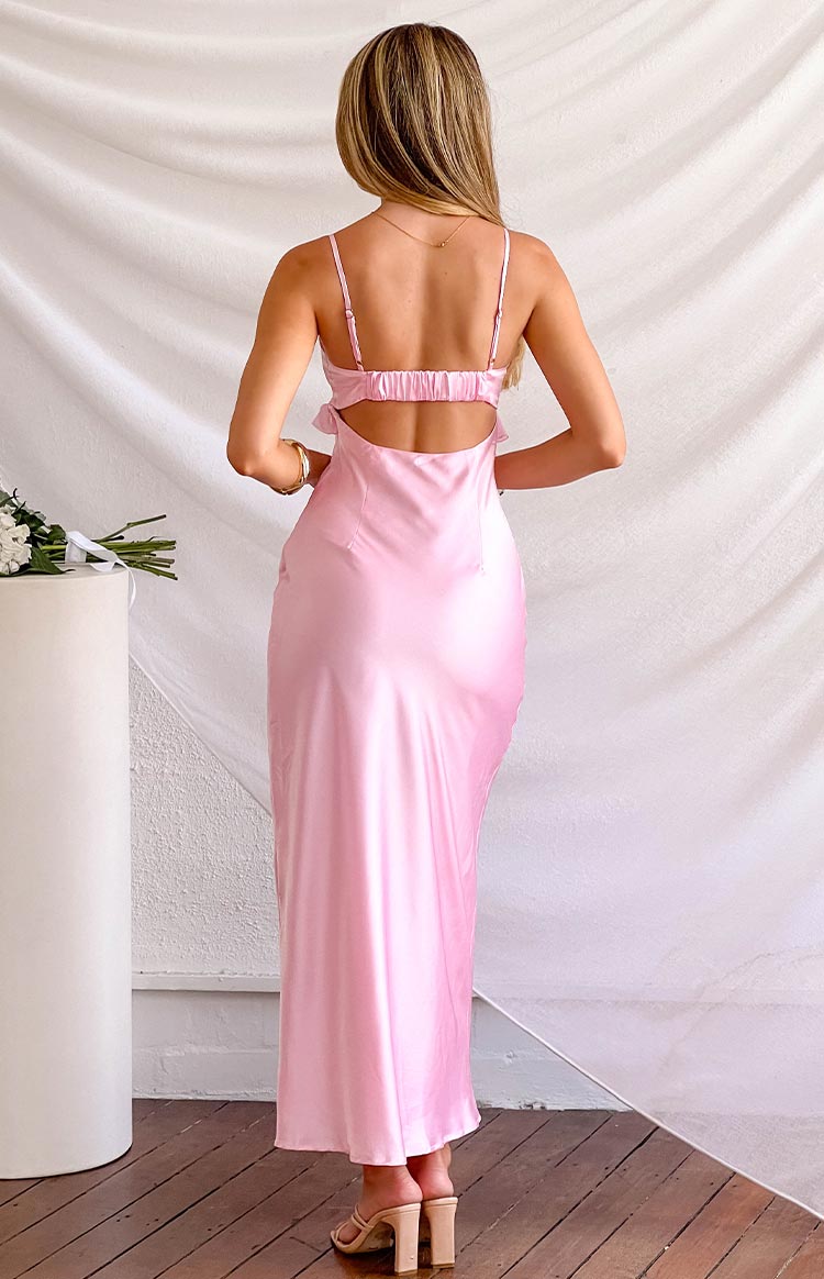 Rear view of a pink satin maxi dress with spaghetti straps, a ruched elasticated back band, and a cutout detail