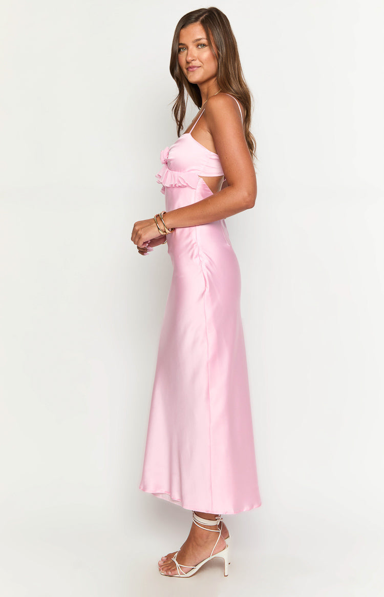 Side view of a pink satin maxi dress with ruffled bust detail and side waist cutouts