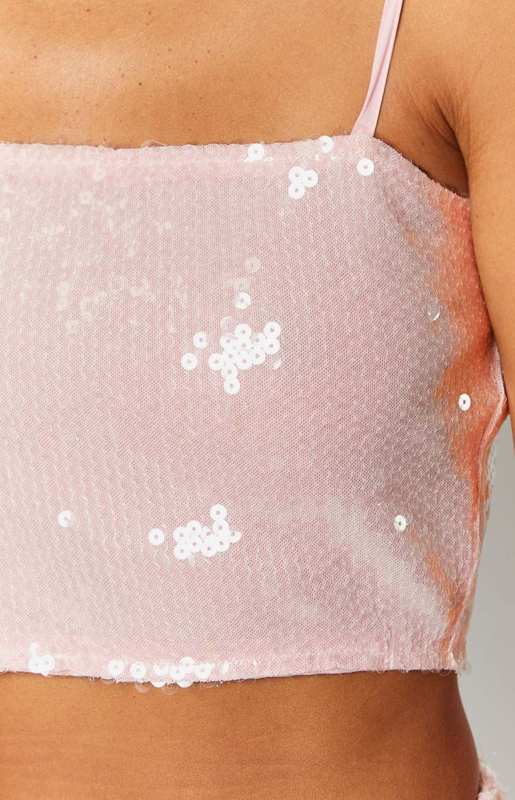 Close-up of the pink sequin fabric with individual white sequins and a thin spaghetti strap
