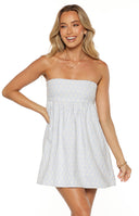 A studio shot from the neck to the mid-thigh of our model wearing a short strapless mini dress. This dress features a light blue and white gingham pattern with a small white floral print layered over it. It has a straight-across neckline a smocked bodice for a close fit and a relaxed slightly flared skirt.