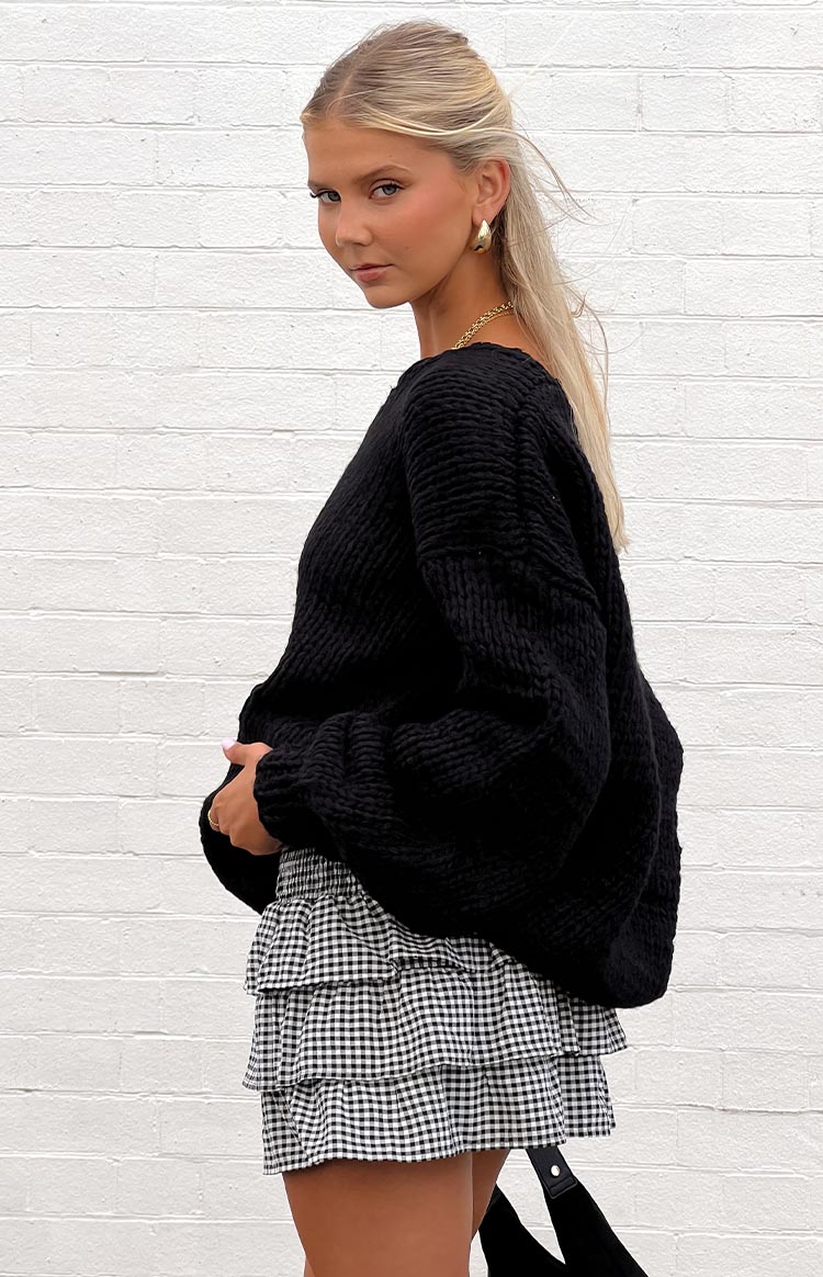 Side view of the black and white gingham mini skirt with a shirred elastic waistband and three ruffled tiers