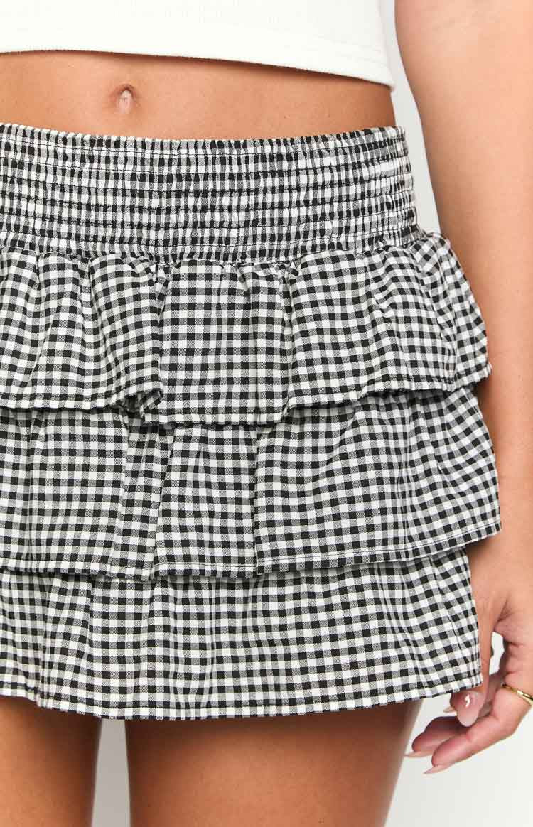 Detail shot of the black and white gingham skirt with a shirred elastic waistband and three tiered ruffles
