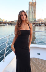 Black mesh maxi dress with a square neckline, thin spaghetti straps, and a fitted bodice