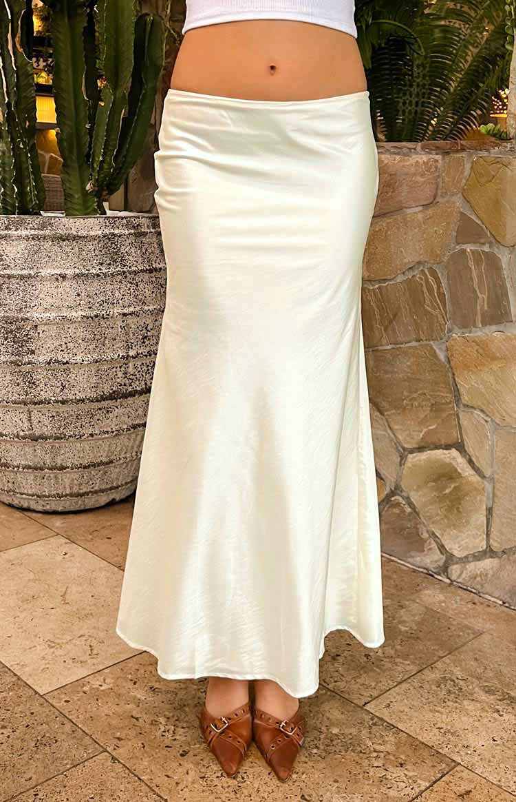 Full length view of a cream satin maxi skirt with a low-rise waist and flowing silhouette
