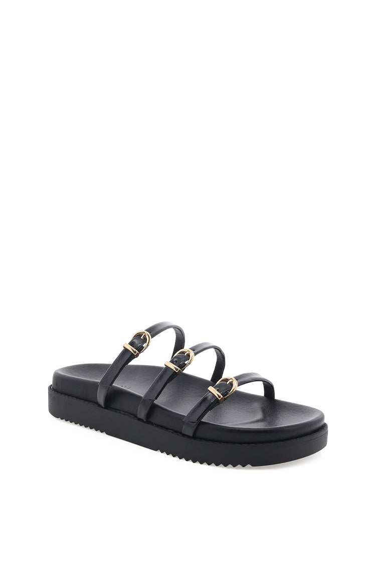 Side view of black slides with three thin straps and gold buckles on a thick ridged sole
