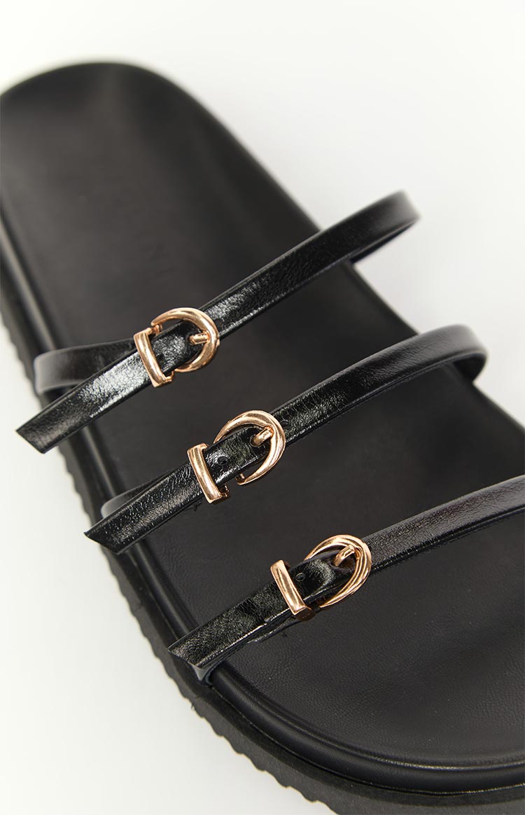 Detail shot of the three thin black patent straps with small gold buckles